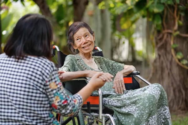An elderly woman smiling while chatting outdoors
