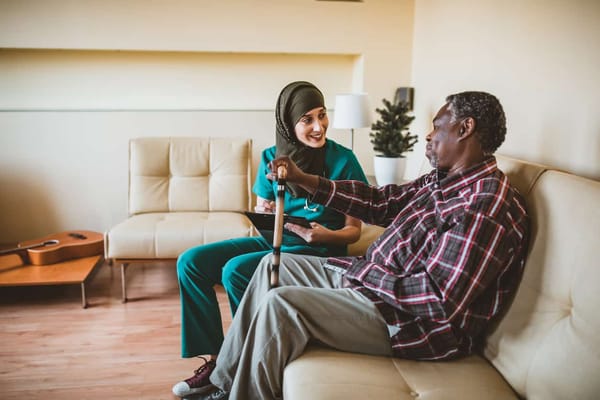 Nurse and resident chatting in a comfortable lounge