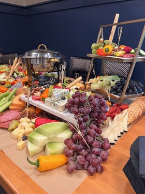 A beautifully arranged food display with fruits and cheeses