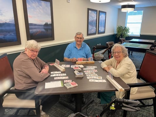 Residents playing a card game in a common area