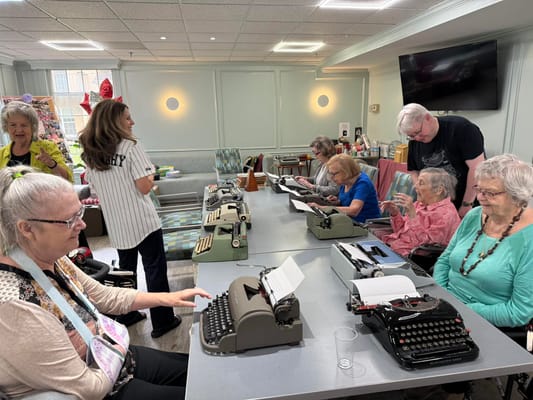 Residents engaging in a typewriter activity in a common area