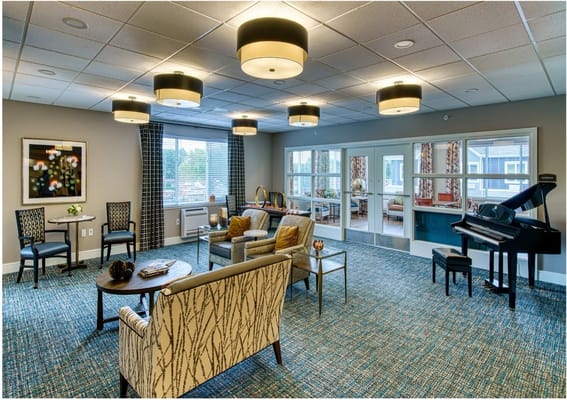 Bright common area with comfortable seating and a piano