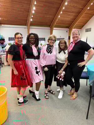 Residents and staff dressed in fun retro costumes at a community event