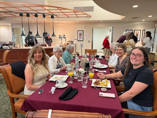 Residents and staff dining together in a bright dining room