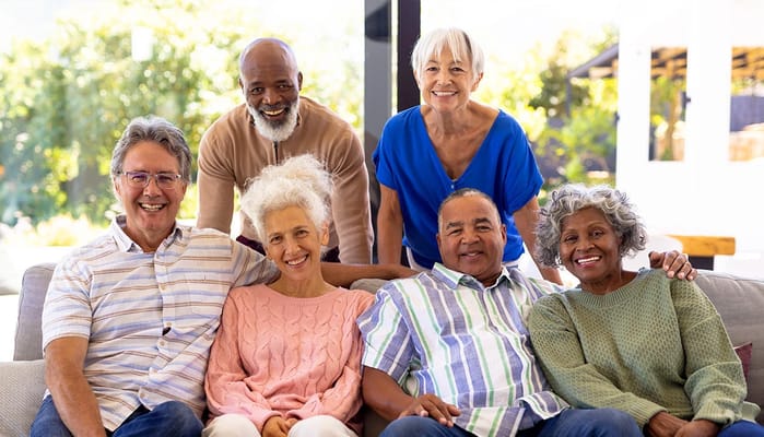 Residents and staff smiling together in a common area
