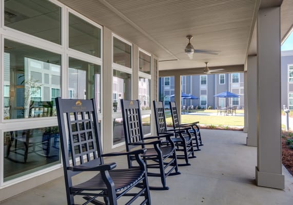 Outdoor seating area with rocking chairs and shaded patio