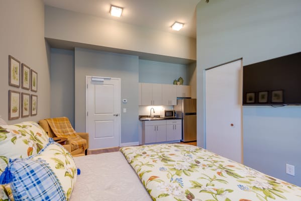 Cozy resident room with floral bedding and kitchenette