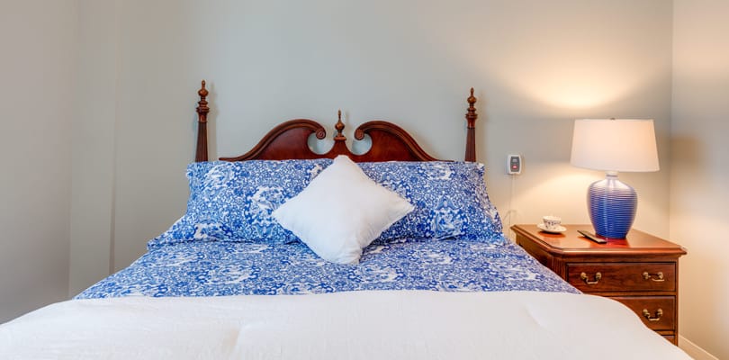 Cozy bedroom with a floral comforter and lamp