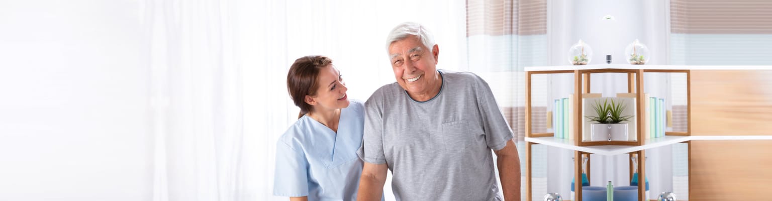 A caregiver assisting a senior resident in a bright interior