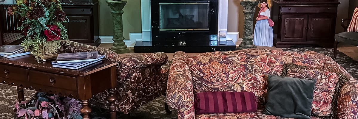 Cozy lobby area with floral sofas and a decorative statue