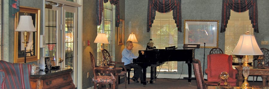 Resident playing piano in a common area