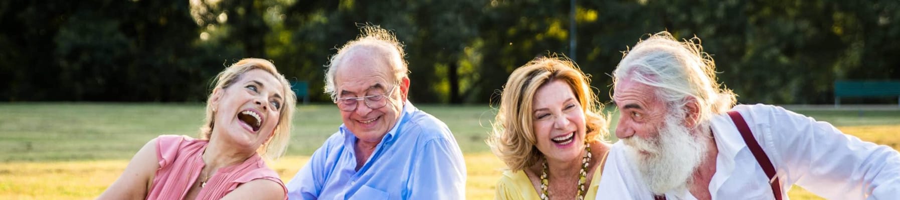 Four seniors enjoying a lively moment outdoors