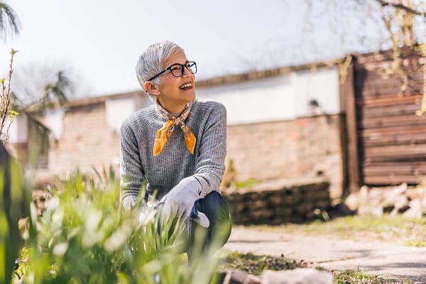 Senior woman enjoying gardening in a sunny outdoor space