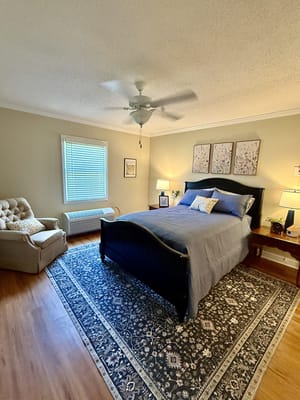 A cozy resident room with a bed and chair