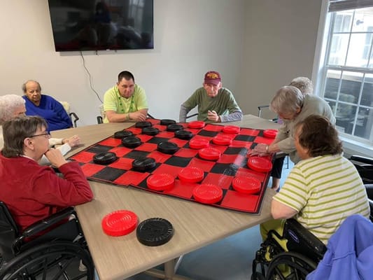 Residents playing checkers in an activity room