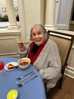A resident enjoying a meal in the dining room