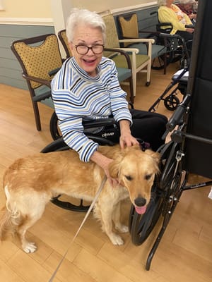 Resident interacting with a dog in a common area