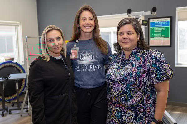 Three staff members posing in an activity area