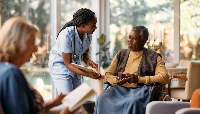 Staff assisting a resident in a cozy living area