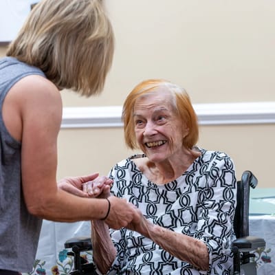A staff member interacting with a smiling resident in a common area