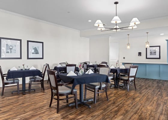 Elegant dining room setup with dark tables and floral centerpieces