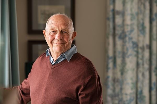 Smiling elderly man in a cozy interior setting