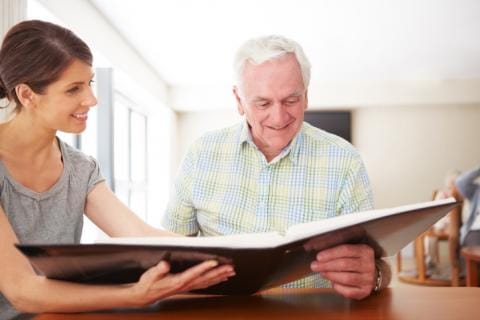 Staff member interacting with a resident over a photo album