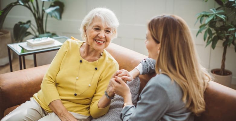 Two women sharing a joyful conversation in a cozy interior