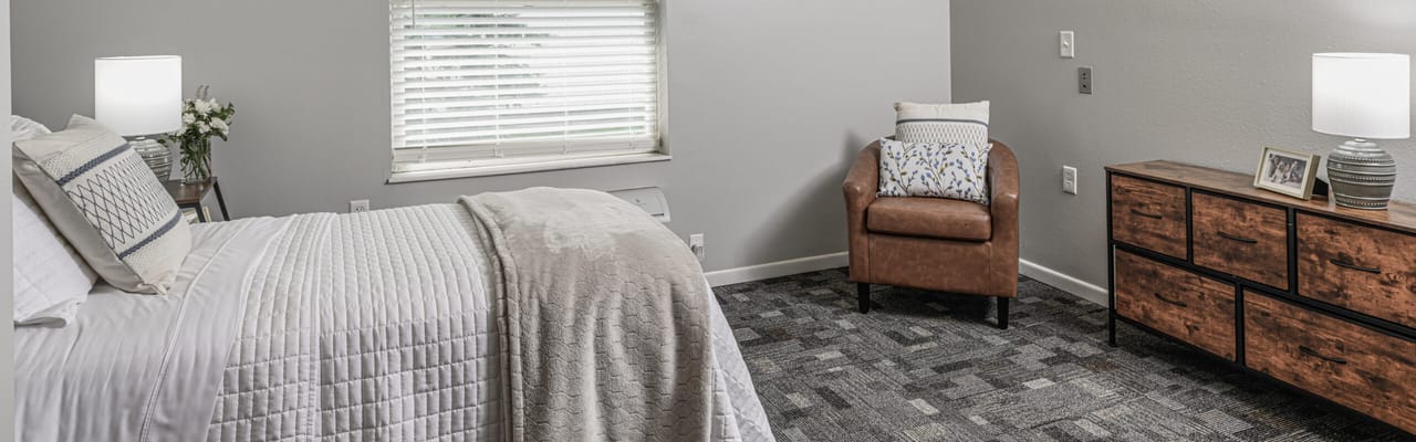 Cozy resident room with a bed and armchair