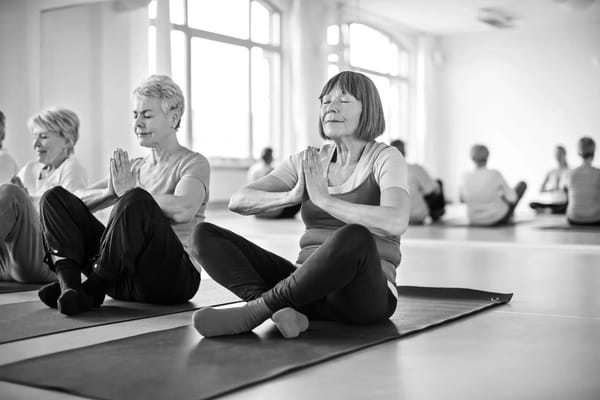 Residents participating in a yoga class in an activity room