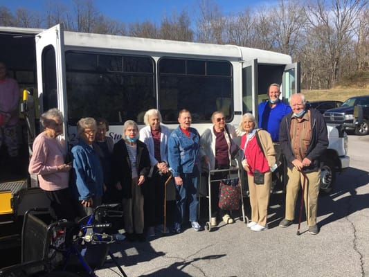 Residents posing outside a facility shuttle bus.