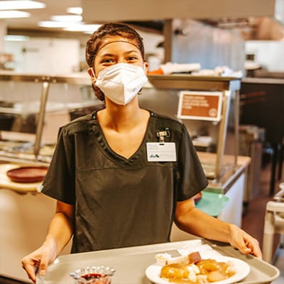 Staff member serving food in the dining area