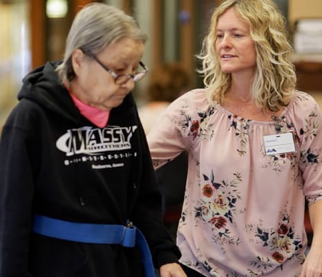 Staff assisting a resident in a hallway