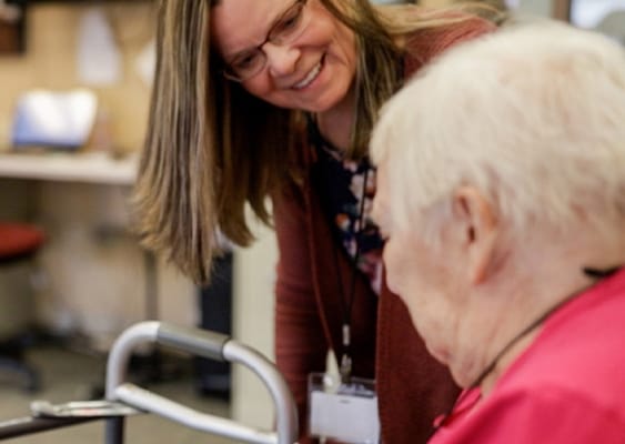 Staff member assisting a resident in a facility setting