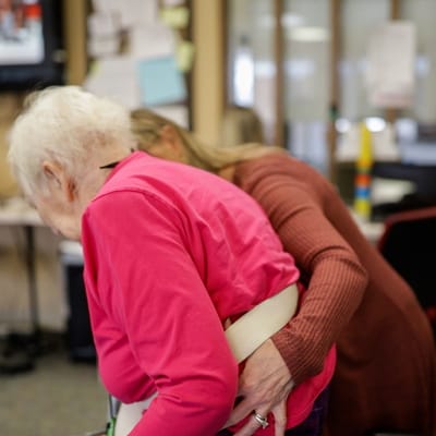 Staff assisting a resident in a care setting