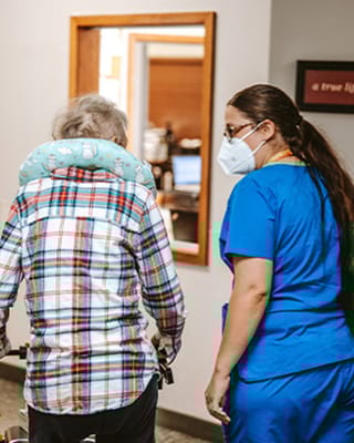 A staff member assisting a resident in an interior setting