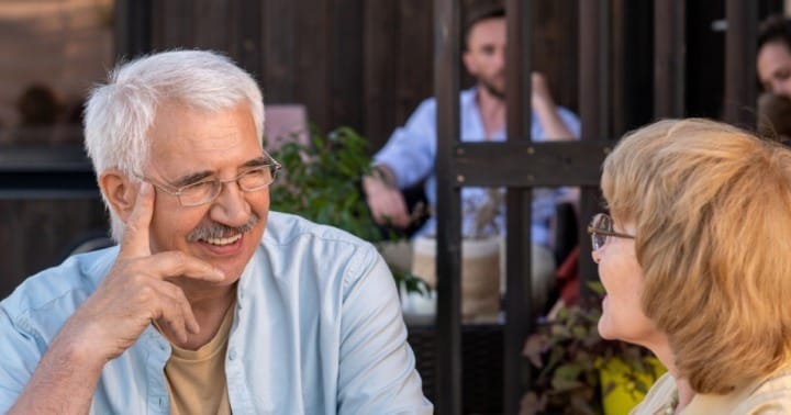 Two older adults engaging in conversation outdoors