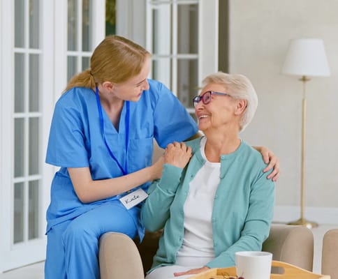 A caregiver interacting with a senior resident in a cozy indoor setting
