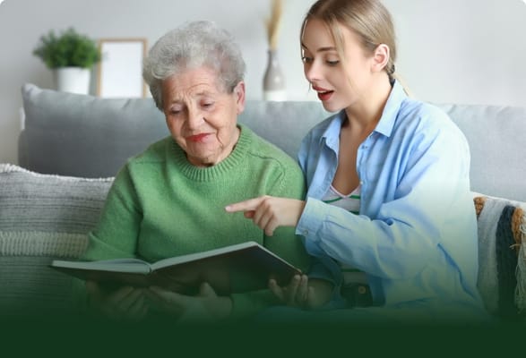 A caregiver reading a book with a senior resident