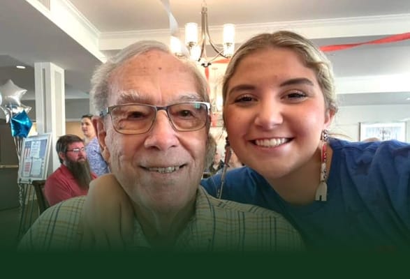 A resident and staff member smiling together in a common area