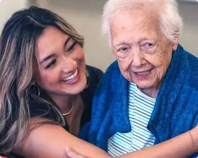 A caregiver and resident smiling together