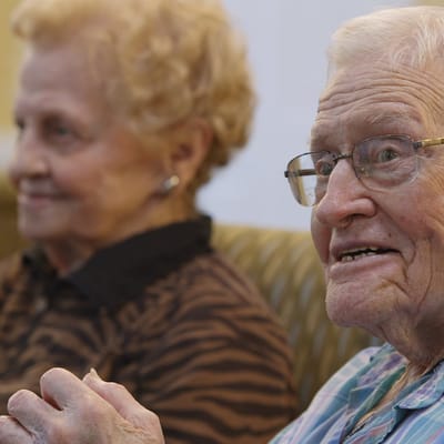 Two elderly residents smiling in a lounge area
