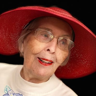 Senior resident smiling with a red hat