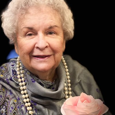 Smiling resident holding a flower