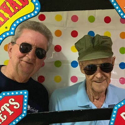 Two residents wearing sunglasses and smiling together