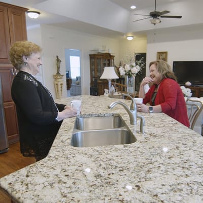 Two residents enjoying conversation in a cozy kitchen