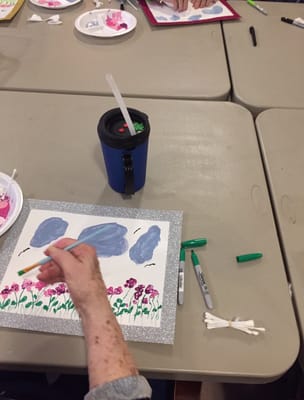 Resident participating in an art activity at a table