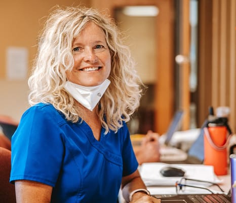 Staff member smiling at a desk in a facility