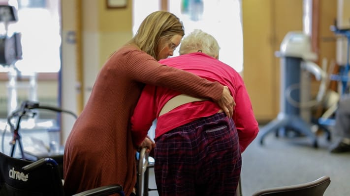 Caregiver assisting a resident in a common area