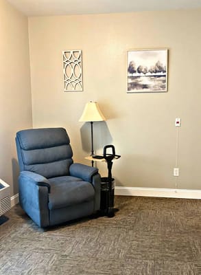Cozy resident room with a recliner and lamp
